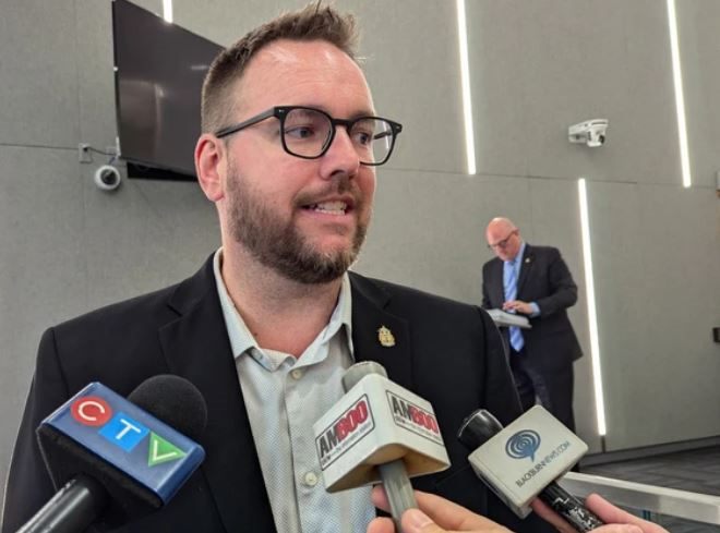 Mark McKenzie fielding questions from local television and radio reporters at a media scrum
